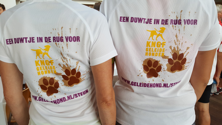 KNGF-hardloopshirts van deelnemers aan Dam- tot Damloop met daarop modderpootjes en Een duwtje in de rug voor de geleidehond