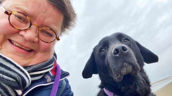 Een selfie van Dominieke en haar zwarte labrador Nike op het strand