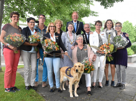 Groepsfoto van vrijwilligers van KNGF Geleidehonden met een onderscheiding en de burgemeester